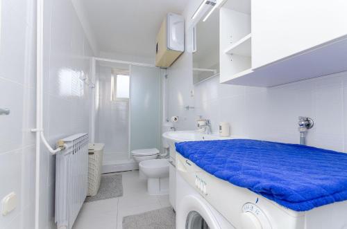 a white bathroom with a sink and a toilet at Apartment Vito in Postira