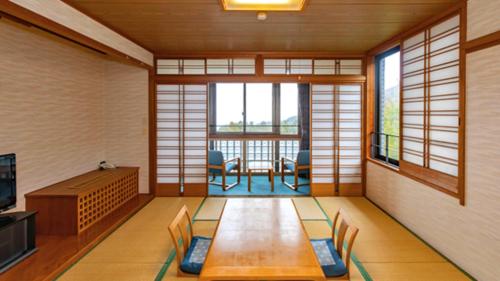 a room with a living room with a table and chairs at Kyukamura Tsumagoi-Kazawa in Tsumagoi