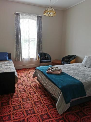 a bedroom with a bed and two chairs and a window at Railton Hotel in Railton
