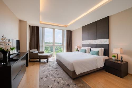 a bedroom with a large bed and a living room at North Park Serviced Apartment Bangkok in Bangkok