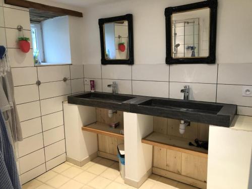 uma casa de banho com dois lavatórios e dois espelhos em Gîte Montignac-le-Coq, 3 pièces, 6 personnes - FR-1-653-4 em Montignac-le-Coq