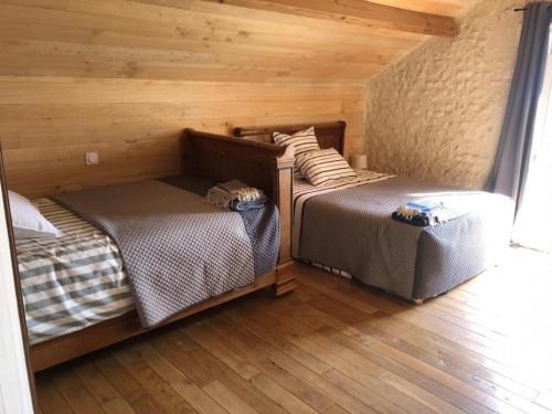 2 Betten in einem Zimmer mit Holzwänden und Holzböden in der Unterkunft Gîte Montignac-le-Coq, 3 pièces, 6 personnes - FR-1-653-4 in Montignac-le-Coq