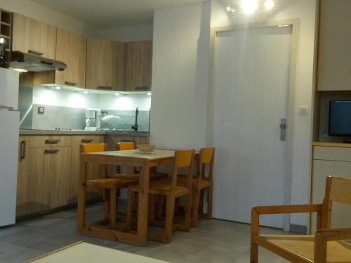 une cuisine avec une table et des chaises dans une pièce dans l'établissement Studio rénové au centre de Villard-de-Lans avec coin montagne - 4 pers., balcon, WiFi, proche commerces. - FR-1-689-6, à Villard-de-Lans