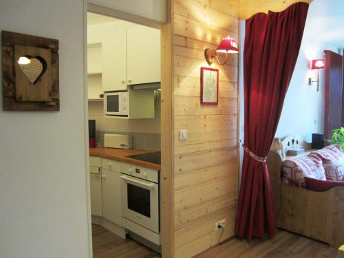 - une petite cuisine avec un comptoir et un rideau rouge dans l'établissement Beau 3 pièces, 8 pers, pied des pistes à Villard-de-Lans - FR-1-689-17, à Villard-de-Lans