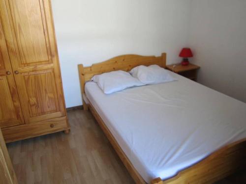 - un lit avec deux oreillers et une table de nuit dans une chambre dans l'établissement Appartement 6 pers au pied des pistes – Balcon, cuisine équipée, parking gratuit - FR-1-689-19, à Villard-de-Lans