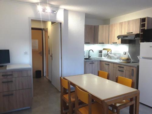 d'une cuisine avec une table et des chaises jaunes. dans l'établissement Studio cabine rénové, 100m du centre du village, Villard-de-Lans - FR-1-689-22, à Villard-de-Lans