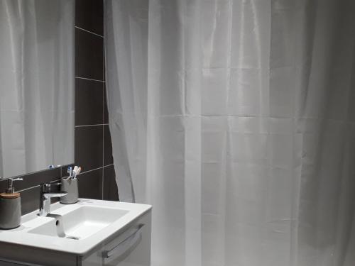 baño con lavabo y cortina de ducha blanca en Appartement Villard-de-Lans, 3 pièces, 8 personnes - FR-1-689-8, en Villard-de-Lans