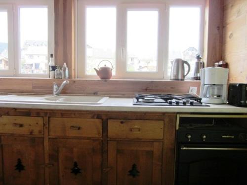 une cuisine avec un évier, une cuisinière et des fenêtres dans l'établissement Grand 100m² avec 3 chambres, parking et Wifi au centre du village - FR-1-689-36, à Villard-de-Lans