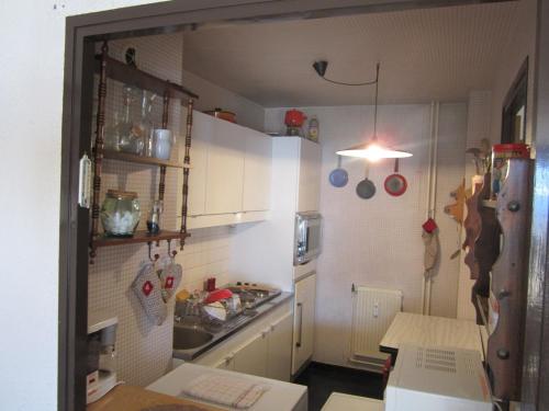 małą kuchnię z białymi szafkami i zlewem w obiekcie Appartement 2P plein sud, centre Villard de Lans, balcon, parking, pour 6 pers - FR-1-689-34 w mieście Villard-de-Lans