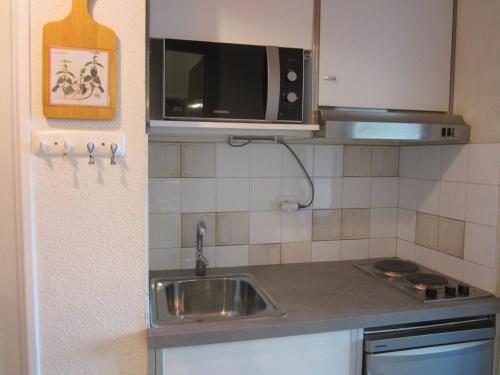 une petite cuisine avec un évier et un micro-ondes dans l'établissement Studio coquet 21m², 4 pers, pied des pistes, Côte 2000, balcon, prox. commerces, parking gratuit - FR-1-689-42, à Villard-de-Lans