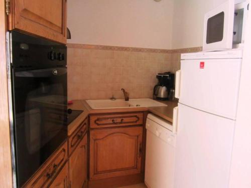 une cuisine avec un réfrigérateur blanc et un évier dans l'établissement 3 pièces 64m² au pied des pistes - 6 à 8 pers. - Balcon - Parking - FR-1-689-27, à Villard-de-Lans