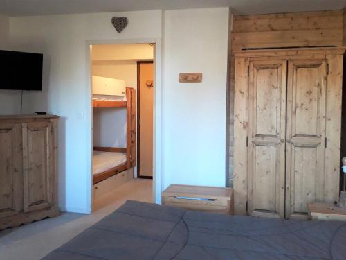 - une chambre avec un lit, une télévision et un placard dans l'établissement Chaleureux 2 pièces cabine rénové - Centre village, proche commerces et ski - FR-1-689-32, à Villard-de-Lans