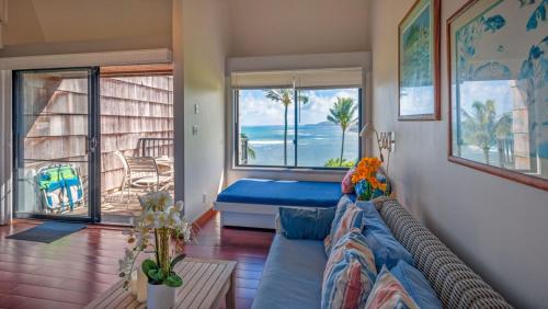 a living room with a couch and a view of the ocean at Sealodge E6 in Princeville