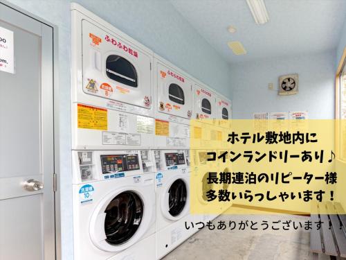 a laundry room with four washing machines in a room at Southern Village Okinawa in Kitanakagusuku