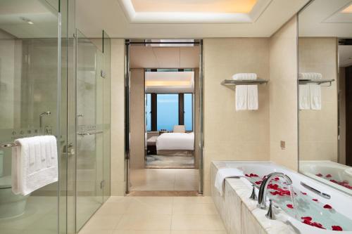 a bathroom with a shower and a sink and a tub at Yun Hotel Wuhan in Wuhan