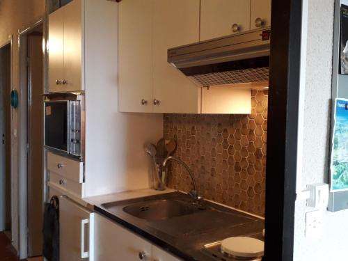 une cuisine avec des armoires blanches et un évier dans l'établissement Studio 4 pers, skis aux pieds, Villard-de-Lans - FR-1-689-46, à Villard-de-Lans