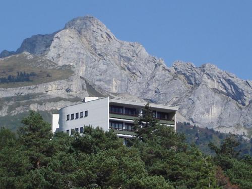 a building in front of a mountain with trees at Studio Villard-de-Lans, 1 pièce, 4 personnes - FR-1-689-46 in Villard-de-Lans