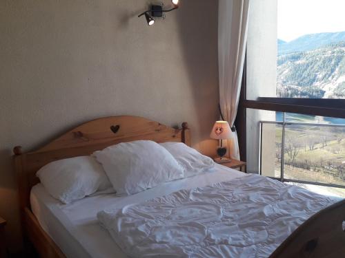 łóżko z białą pościelą i oknem z widokiem w obiekcie Très beau T3 au pied des pistes pour 6/7 personnes à Villard-de-Lans - FR-1-689-48 w mieście Villard-de-Lans