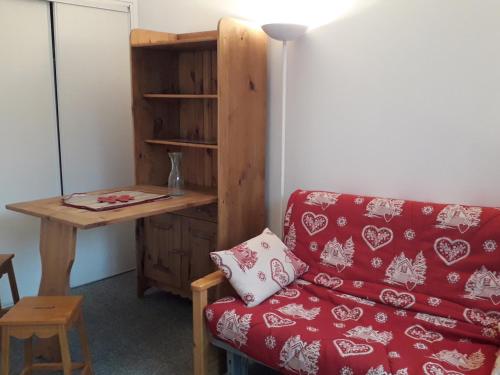 - un salon avec un canapé rouge et un bureau dans l'établissement Studio coquet au pied des pistes - 2/3 pers, balcon - FR-1-689-69, à Villard-de-Lans