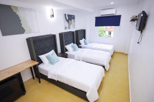 a room with two beds and a flat screen tv at RENTIO HOTEL in Kulim