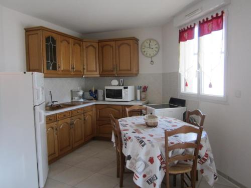 une cuisine avec une table et un réfrigérateur blanc dans l'établissement Studio spacieux 32m², 4 pers., centre de Villard-de-Lans, terrasse, parking, proche commodités - FR-1-689-96, à Villard-de-Lans