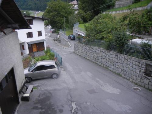 a car parked in a parking lot next to a stone wall at Mansarda 2 del Capitel in Commezzadura