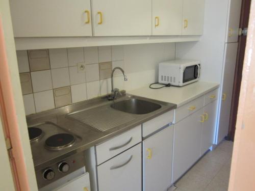 une petite cuisine avec un évier et un micro-ondes dans l'établissement Studio pour 4 à Villard-de-Lans, exposé sud, au pied des pistes - FR-1-689-70, à Villard-de-Lans