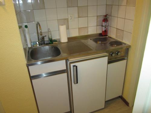 une petite cuisine avec un évier et une cuisinière dans l'établissement Studio 4 pers, pied des pistes, proche commerces et navettes – Villard-de-Lans - FR-1-689-100, à Villard-de-Lans