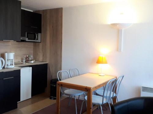 une petite cuisine avec une table et des chaises dans une pièce dans l'établissement Studio cosy 4 pers - Proche village avec balcon et commodités - FR-1-689-77, à Villard-de-Lans