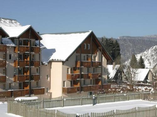 un grand immeuble avec de la neige sur le toit dans l'établissement Studio cosy 4 pers - Proche village avec balcon et commodités - FR-1-689-77, à Villard-de-Lans