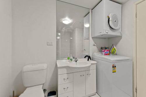 a white bathroom with a toilet and a sink at Exclusive Stays - The Summit in Melbourne