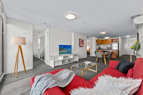 a living room with a red couch and a table at Exclusive Stays - The Summit in Melbourne