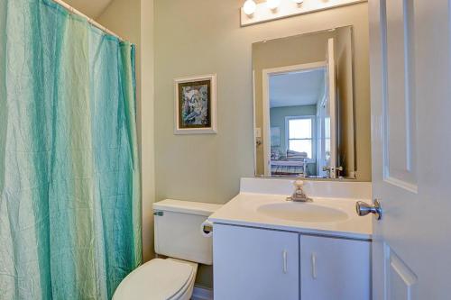 a bathroom with a toilet and a sink and a mirror at Park Topsail Beach in Topsail Beach