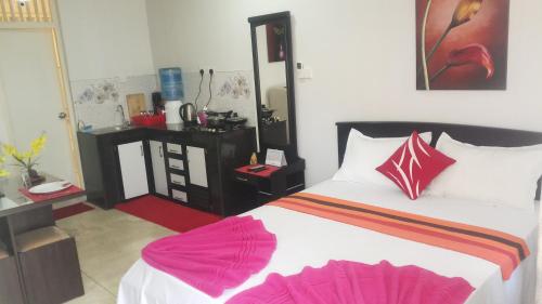 a bedroom with a large bed with pink sheets at WISH RESIDENCE SeaSide, Near Durdans & Vasan eye care Hospital, Colombo 3 in Colombo