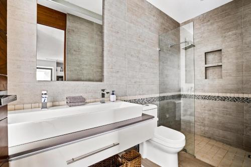 a bathroom with a white sink and a shower at Skyloftpv by LOFT268 in Puerto Vallarta