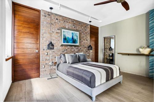 Un dormitorio con una pared de ladrillo y una cama en Skyloftpv by LOFT268 en Puerto Vallarta