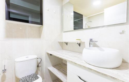 uma casa de banho branca com um WC e um lavatório em 3 Bedroom Beautiful Apartment In Viveiro em Viveiro