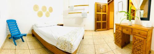 a bedroom with a bed and a blue chair at Casa Karma in Puerto Escondido