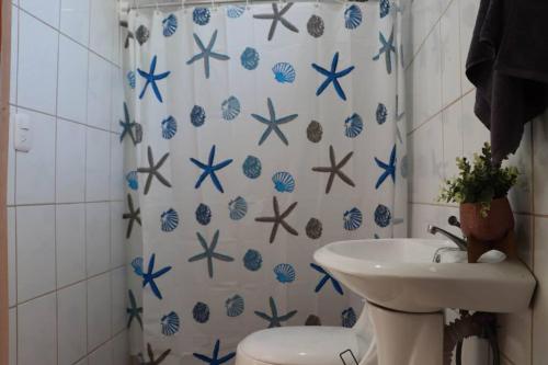 a bathroom with a sink and a blue and white shower curtain at Pura Vida Villa! Beachfront Golf and Country Club Los Delfines 24 hours security in Tambor