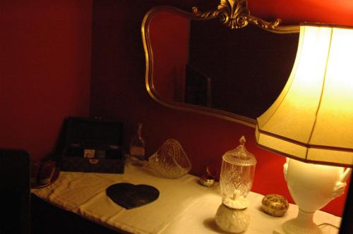 a lamp sitting on a table with a mirror at La Grande Maison in Pas-de-Jeu