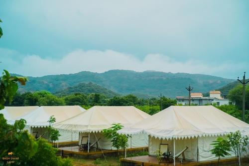 a row of tents with mountains in the background at Ranthambhore Bagh Dwar Camp in Khilchipur
