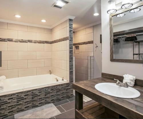 ein Badezimmer mit Badewanne und Waschbecken in der Unterkunft Dollywood Pool Spa Sauna Gym, Walk To Dollywood fireworks view!! in Pigeon Forge