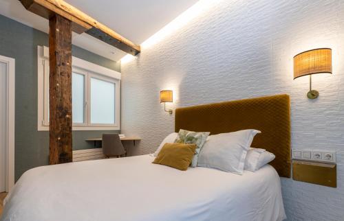 una camera da letto con un grande letto con lenzuola e cuscini bianchi di BIG 4 ROOMS in a Centric Home Parking Included a San Sebastián
