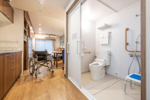 a wheelchair in a bathroom with a toilet and a table at Hotel New Port Yokosuka in Yokosuka