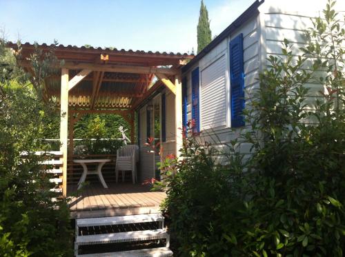 a porch of a house with a table and chairs at Camping Serenella in Bardolino