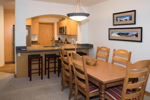 a kitchen and dining room with a wooden table and chairs at 4312 - Two Bedroom Deluxe Creekside Condominiums condo in Solitude