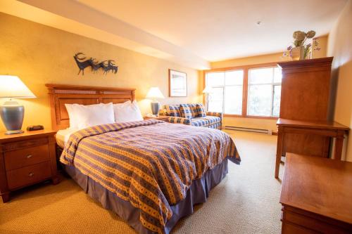 Habitación de hotel con cama y silla en 3309B - Queen Standard Powderhorn Lodge condo en Solitude