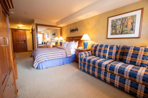 um quarto de hotel com uma cama e um sofá em 3309B - Queen Standard Powderhorn Lodge condo em Solitude