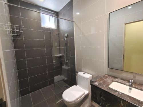 a bathroom with a toilet and a sink and a mirror at Hotel MetraSquare in Melaka
