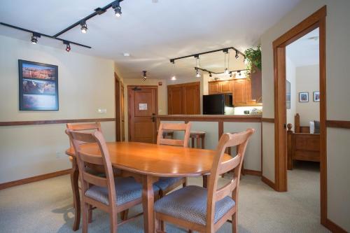 1214 - Two Bedroom Standard Eagle Springs West condo في Solitude: مطبخ وغرفة طعام مع طاولة وكراسي خشبية